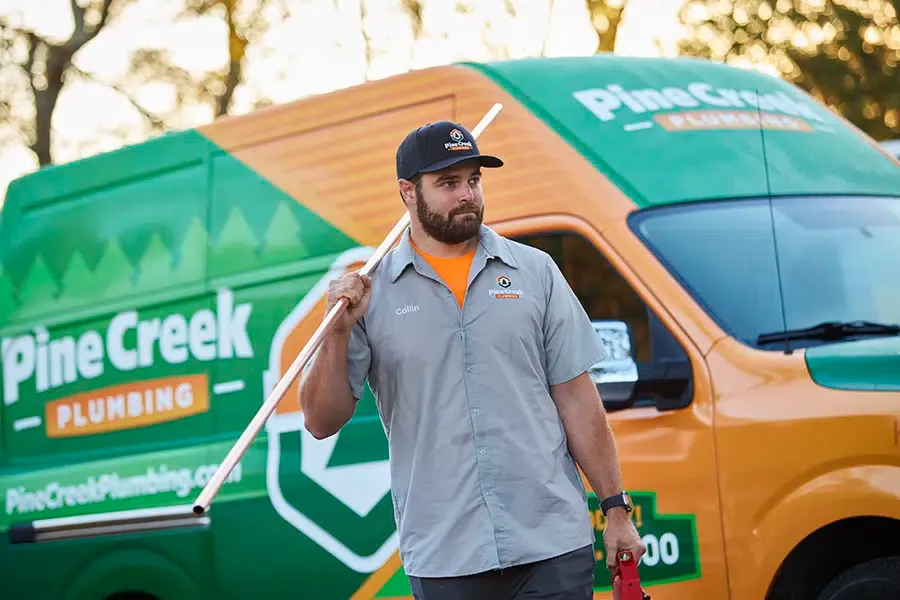 Pine Creek Plumber holding pipe with van behind him