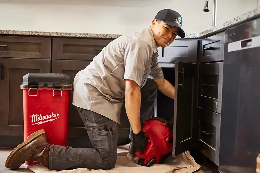 Pine Creek plumber working under kitchen sink